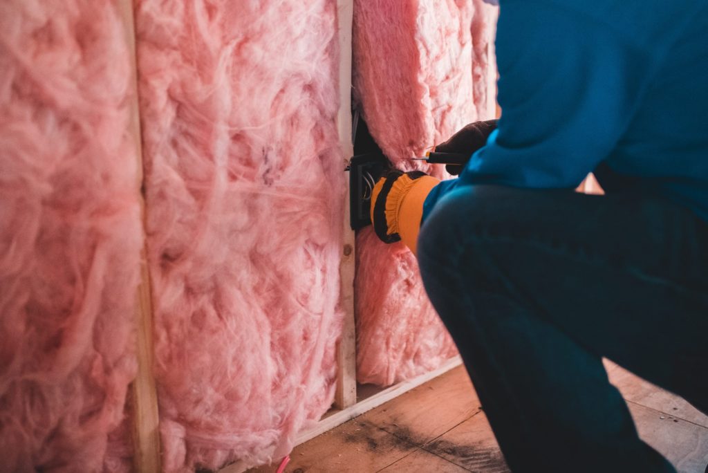 Photograph of person installing wall insulation